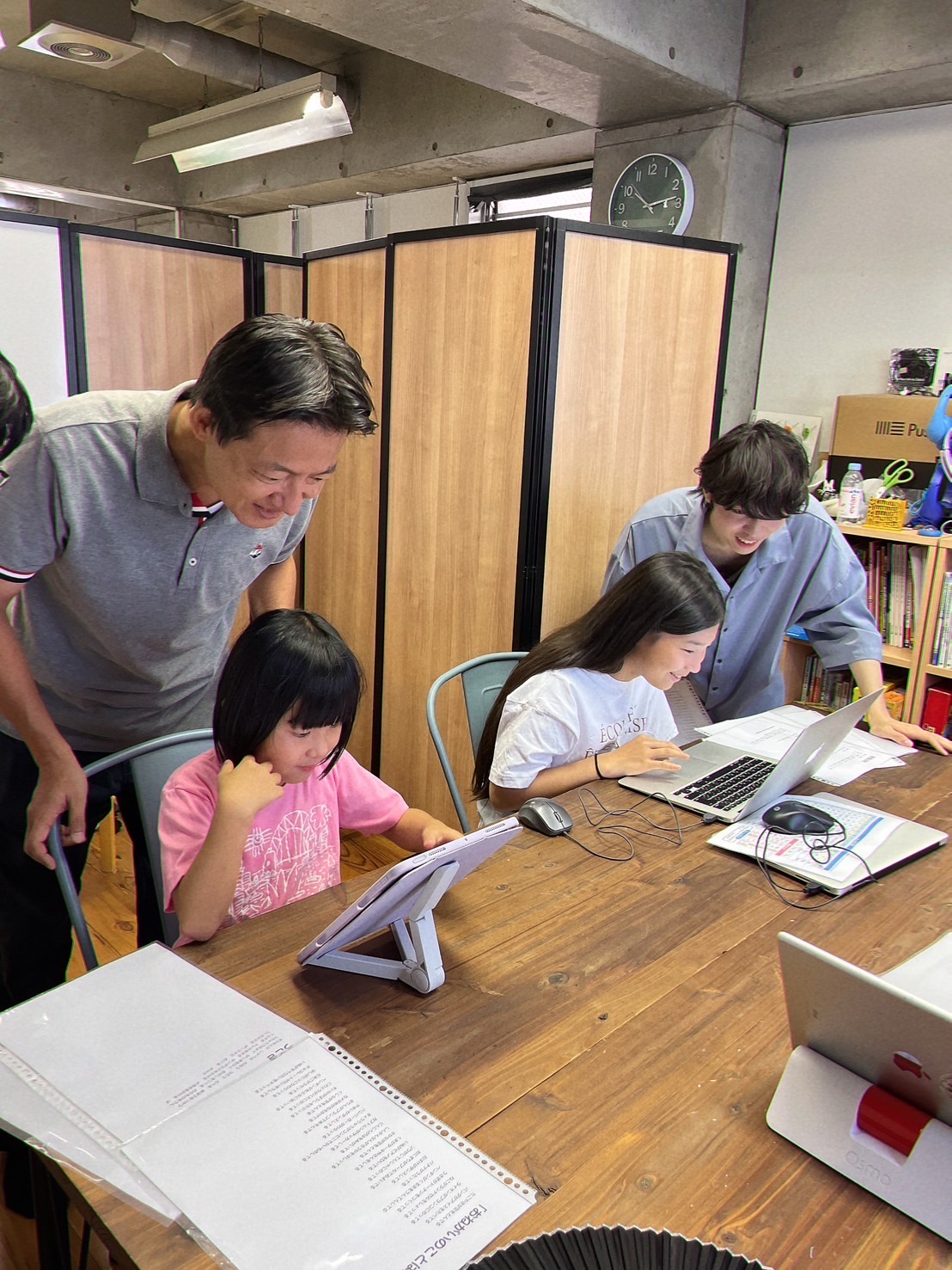 ボランティアスタッフが子どもにタブレットの使い方を教えている様子